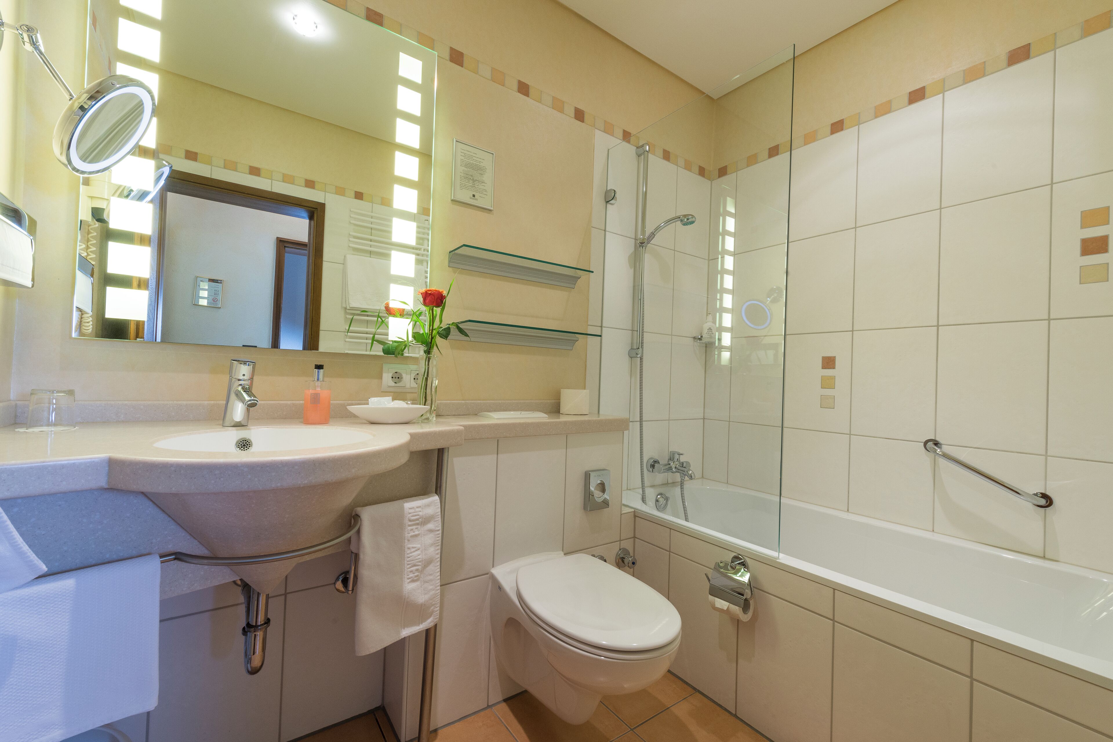 A modern bathroom with a sink, toilet, and shower.