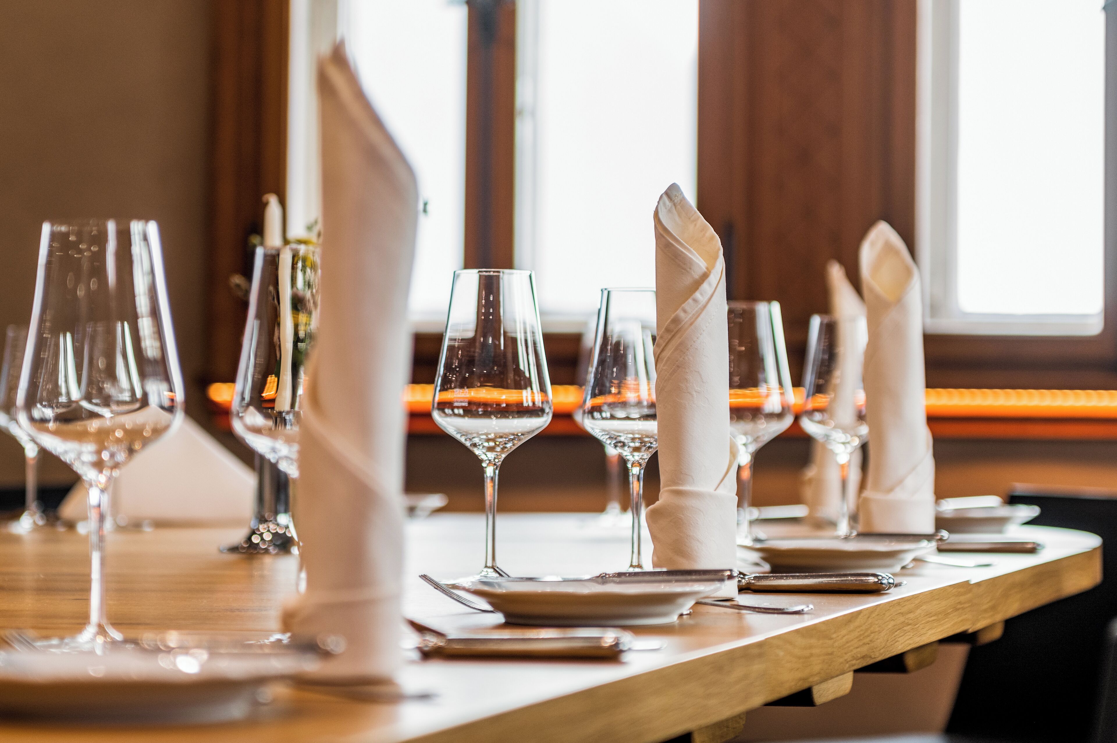 A dining table set with multiple wine glasses, plates, and cutlery.