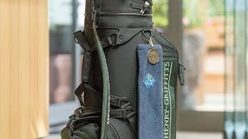 Eine Golftasche mit Handtuch und Golfschläger auf Holzboden.