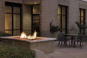 A stone building with large windows, a fire feature, and outdoor seating. - Courtyard by Marriott Sacramento Midtown (Sacramento)