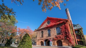 A historic building with ivy-covered brick walls, large arched windows, and a prominent chimney. - New Otani Inn Sapporo (Sapporo)