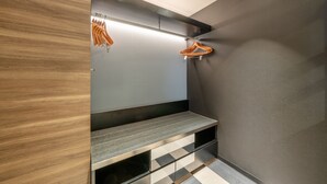 A modern bathroom with a wooden vanity, a mirror, and a bench with storage drawers. - New Otani Inn Sapporo (Sapporo)