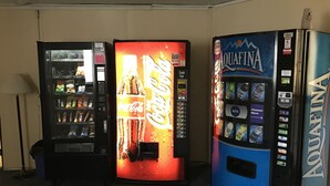 Drei Automaten mit Coca-Cola, Aquafina und anderen Getränken.