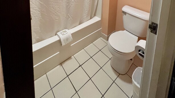 Un baño con bañera, inodoro y toallero.