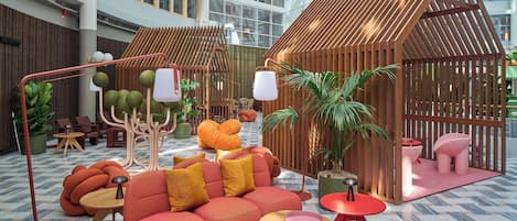 A modern indoor space with a central seating area, a wooden structure, and various plants.