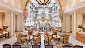 A spacious lobby with a central seating area, a grand chandelier, and a view of a high-rise building through an arched window. - ITC Maratha Mumbai, a Luxury Collection Hotel, Mumbai (Mumbai)