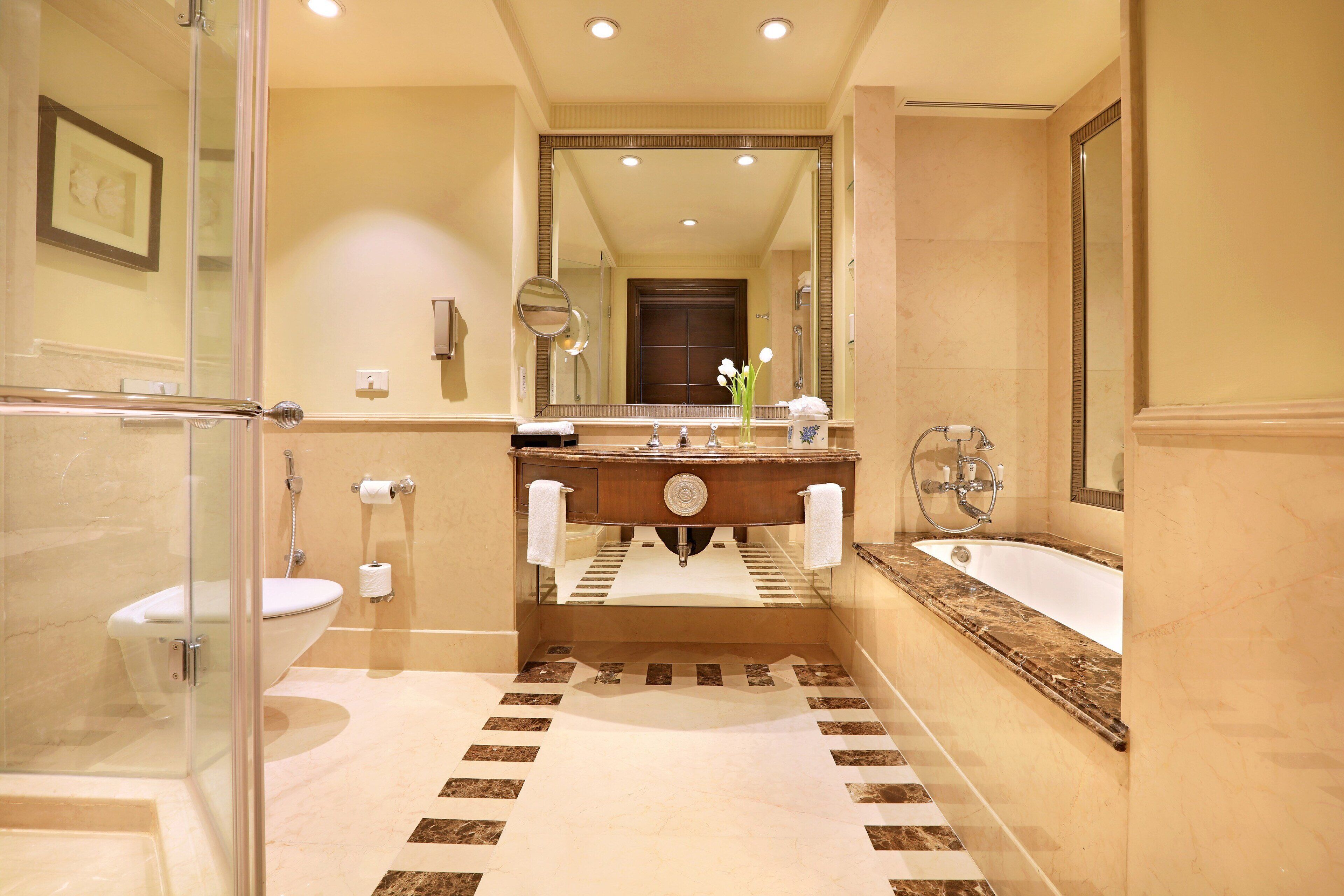 A bathroom with a glass shower enclosure, a sink with a marble countertop, and a bathtub.