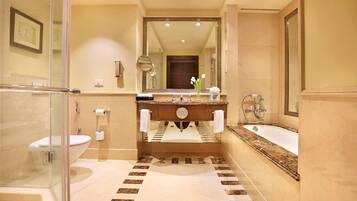 A bathroom with a glass shower enclosure, a sink with a marble countertop, and a bathtub.