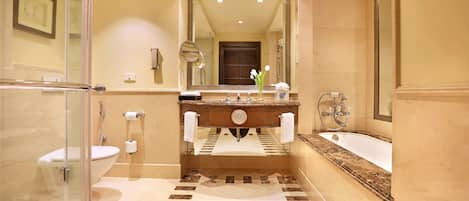 A bathroom with a glass shower enclosure, a sink with a marble countertop, and a bathtub.