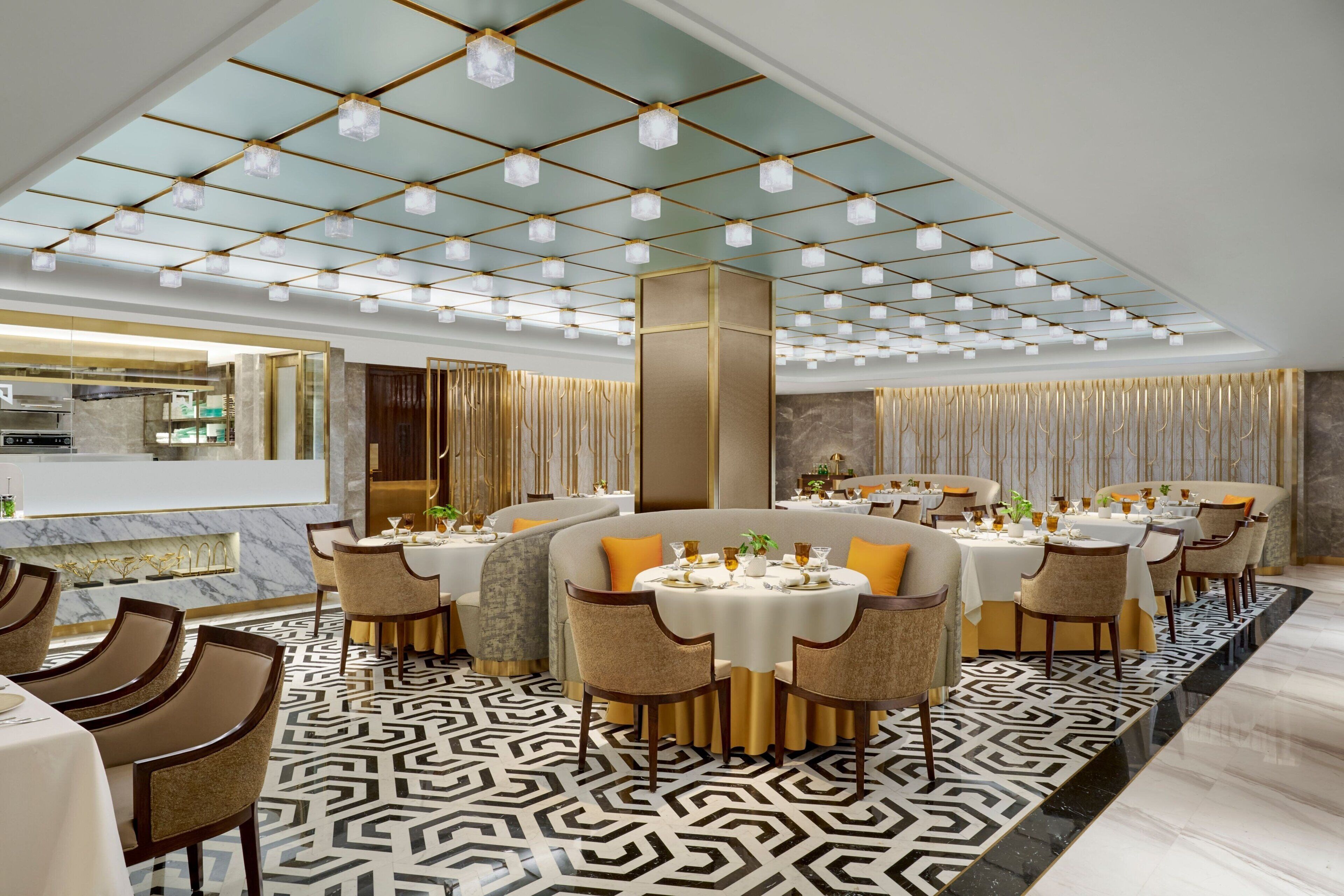 A modern dining area with multiple round tables, chairs, and a patterned floor.