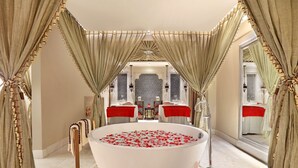 A luxurious bathroom with a large bathtub filled with rose petals, ornate curtains, and a mirror reflecting the room. - ITC Maratha Mumbai, a Luxury Collection Hotel, Mumbai (Mumbai)