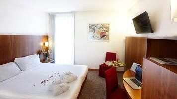 Ylelliset vuodevaatteet, untuvapeitot, tallelokero huoneessa, työpöytä