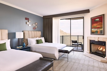 Two large beds with white linens and green pillows, a fireplace, and a large window with an outdoor view. at ADERO Scottsdale Resort, Autograph Collection