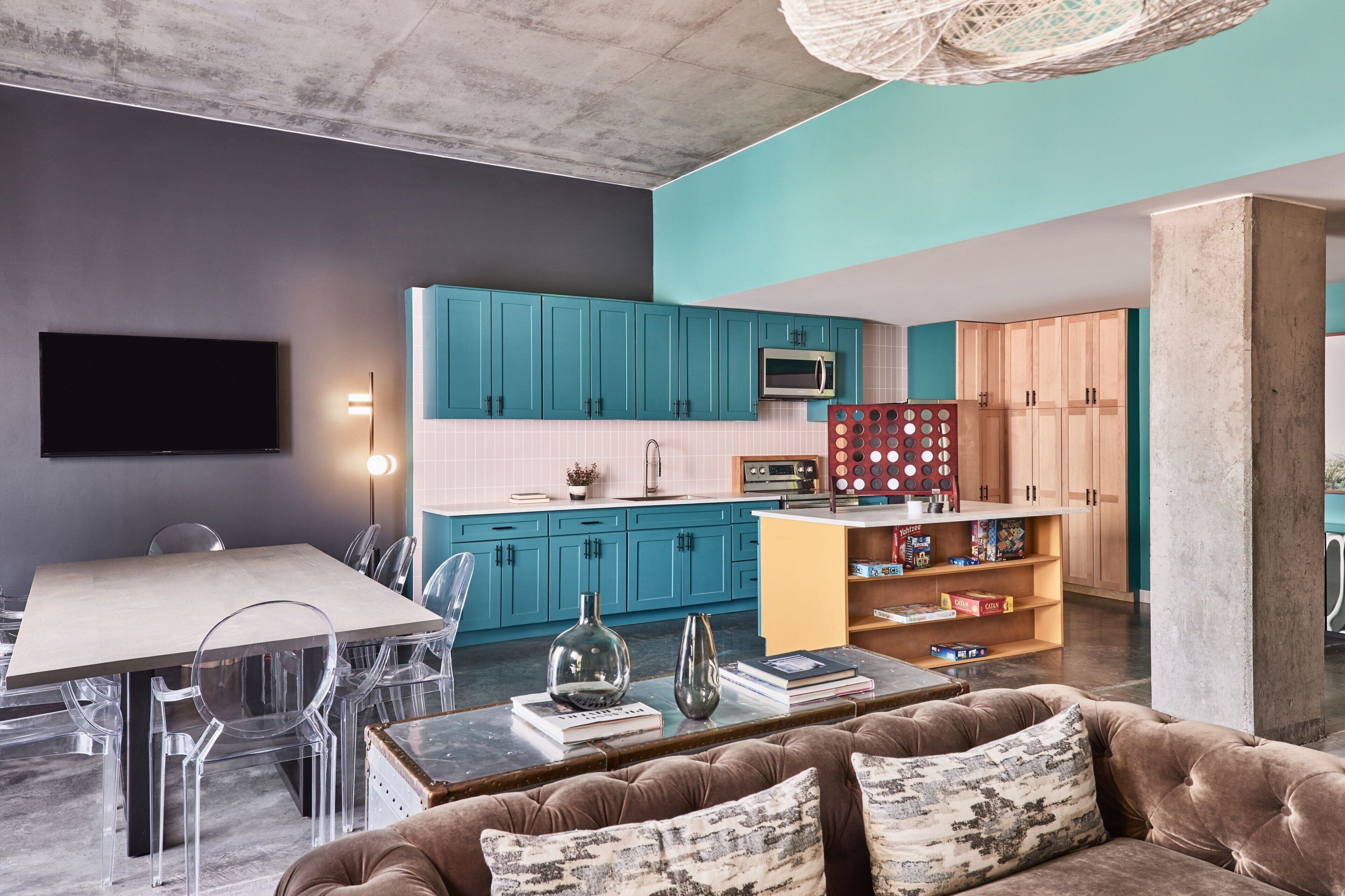 A modern living space with a dining area, kitchen, and seating area.
