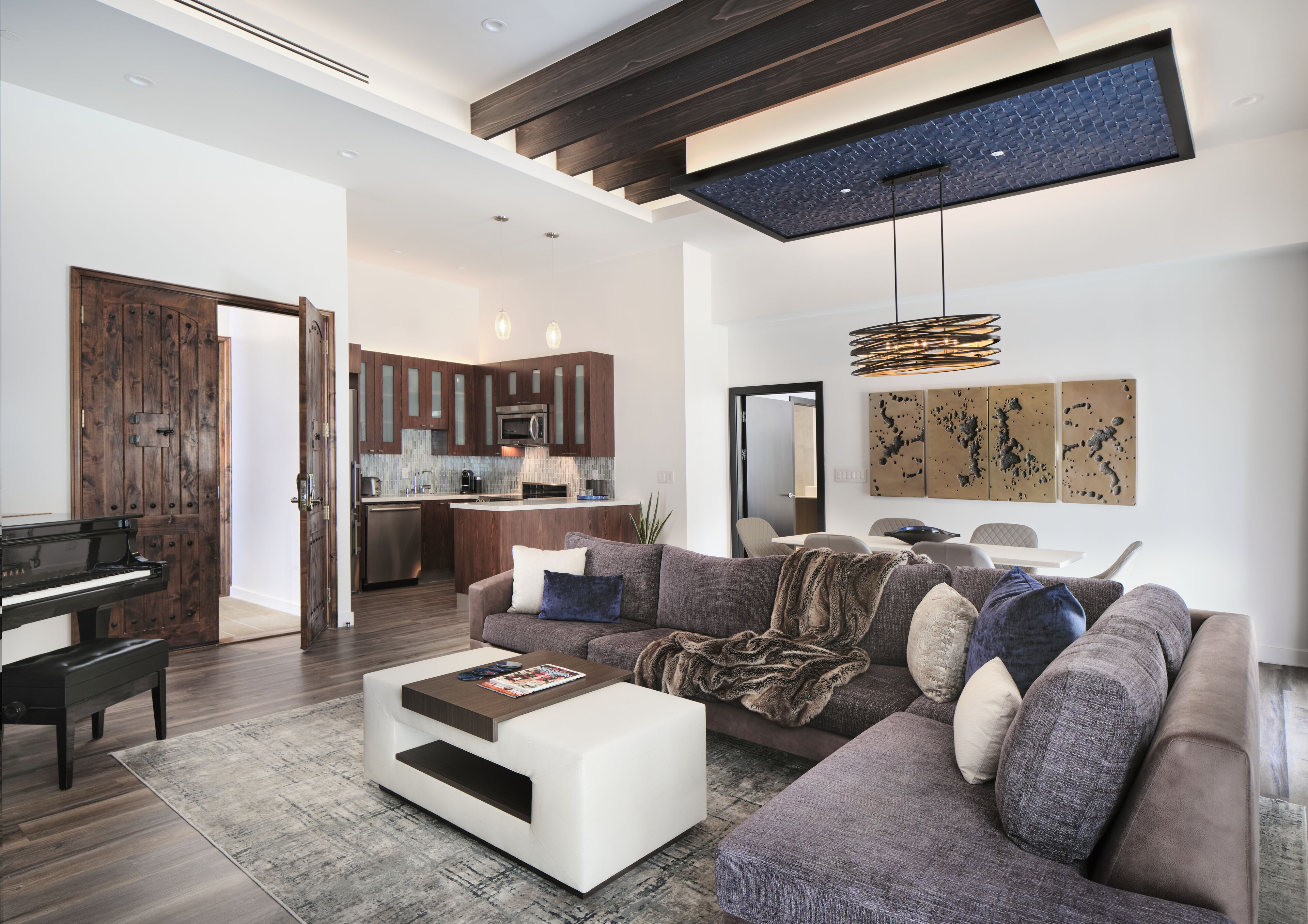 A modern living room with a piano, a large sofa, and a coffee table.