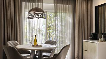 Un coin repas moderne avec une table ronde, quatre chaises, une bouteille de vin et des verres.