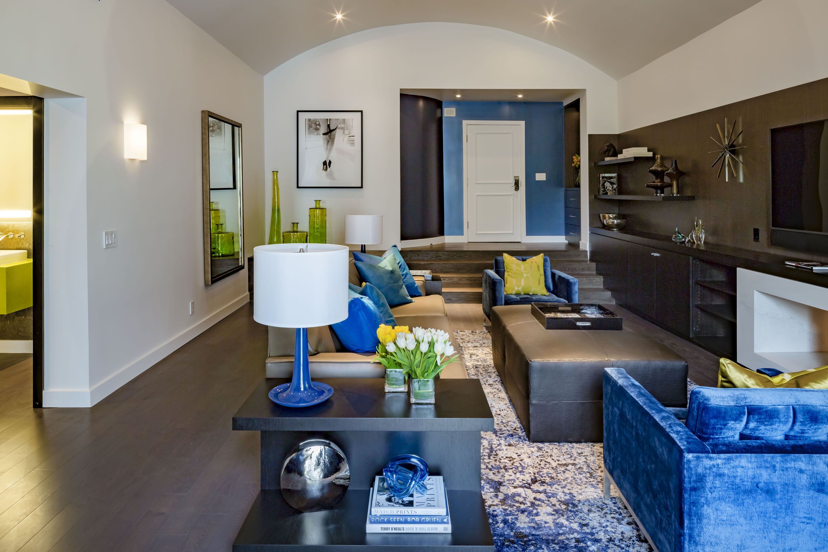 A modern living room with a sofa set, a coffee table with decorative items, and a TV.