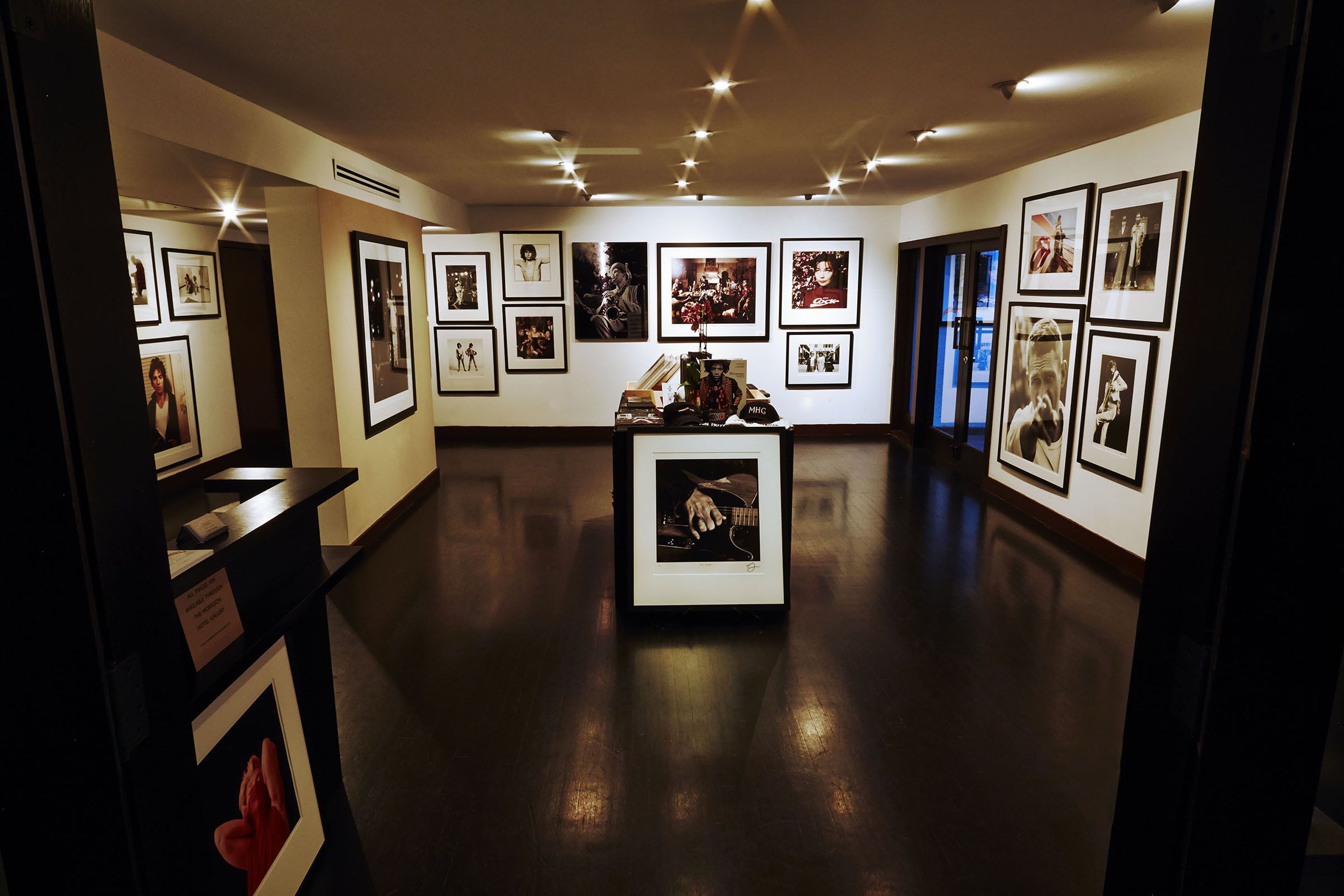 A gallery with framed photographs on the walls and a central display case.