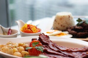 A breakfast plate with bacon, eggs, and potatoes.