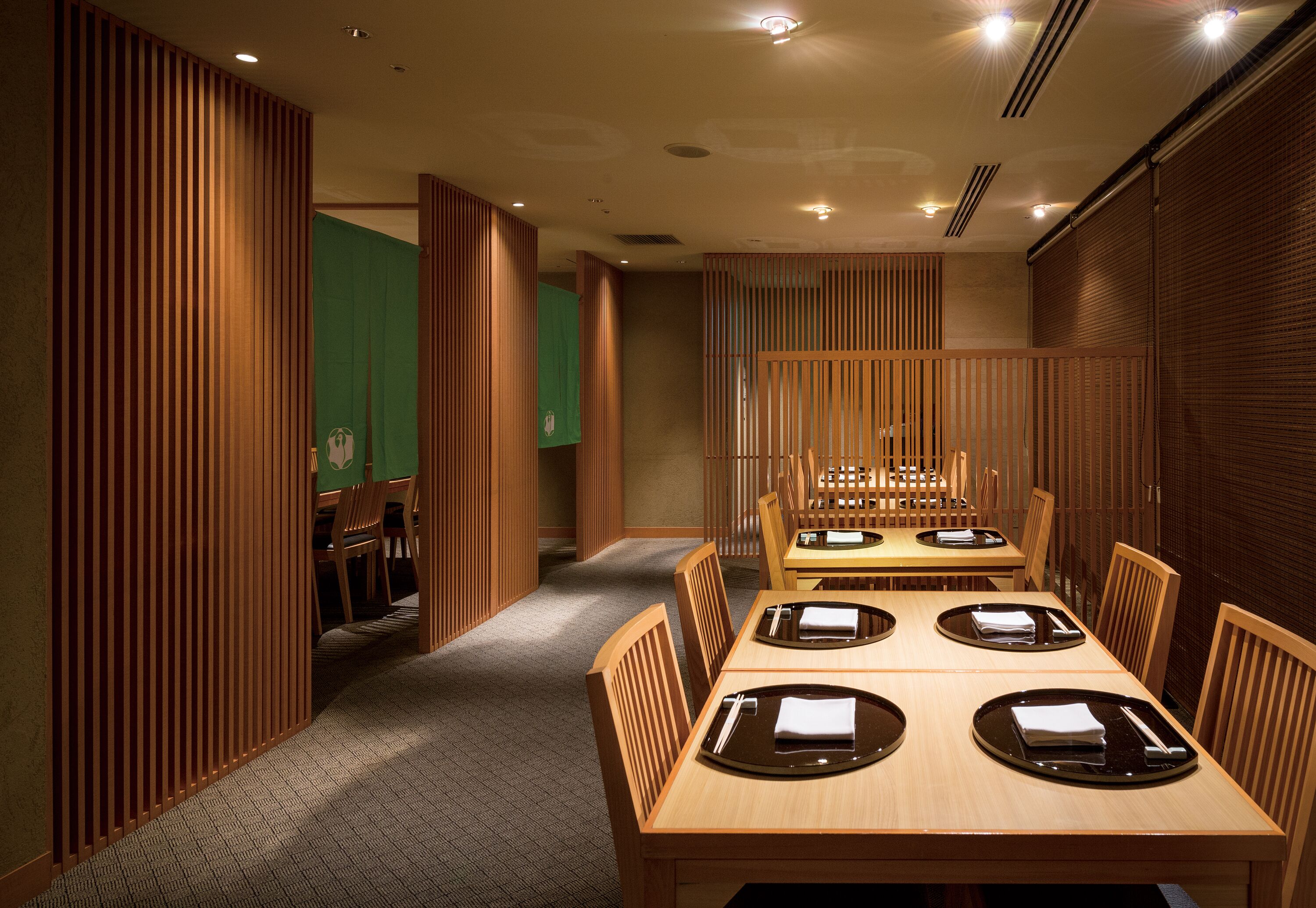 A conference room with wooden paneling, a carpeted floor, and a long table with chairs.