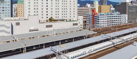 A modern train station with multiple platforms and a high-speed train.