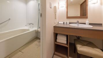 A modern bathroom with a bathtub, a sink, a mirror, and a towel rack.