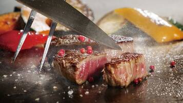 On découpe un steak sur une planche à découper à l’aide d’un couteau.