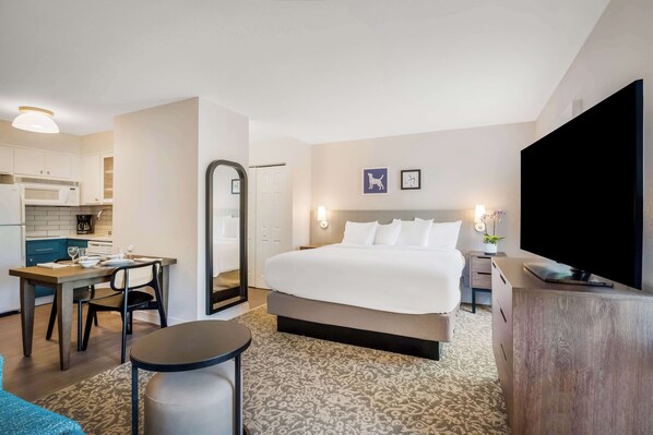 A hotel room with a bed, a desk, a chair, a television, a mirror, and a kitchenette. - Sonesta ES Suites Portland Vancouver 41st Street (Vancouver)