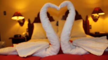 A bed with a heart-shaped towel arrangement.