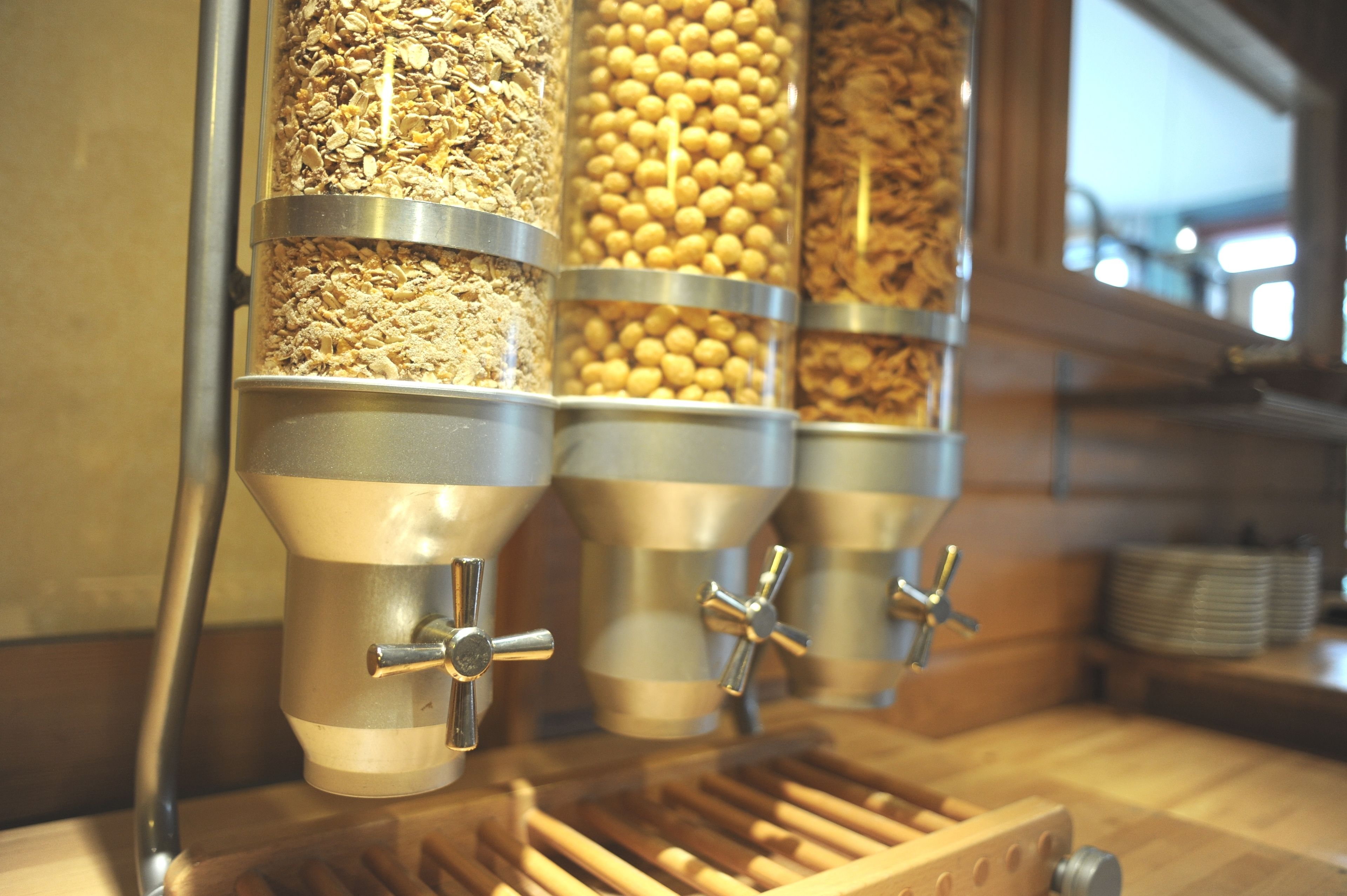 A food dispensing station with multiple containers of granola and other snacks.