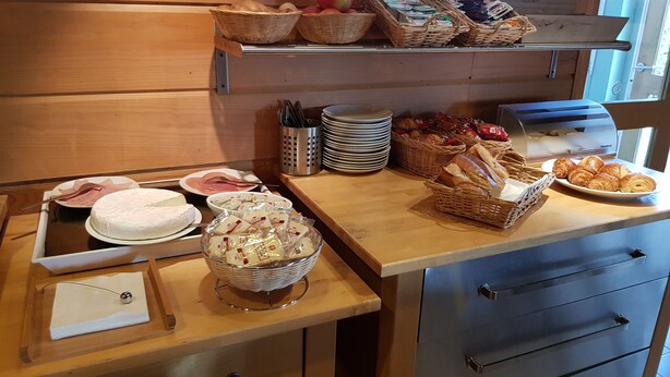 A breakfast buffet setup with various food items and utensils. - Hotel Kiotel Lyon Bron Eurexpo (Bron)