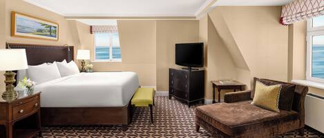 A hotel room with a bed, a television, a dresser, a chair, and a window with a view.