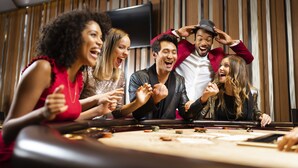 A group of people at a casino table with chips and cards. - Fairmont Le Manoir Richelieu (La Malbaie)