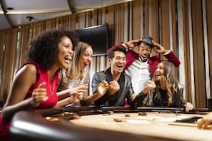 A group of people at a casino table with chips and cards.