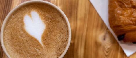 A cup of coffee with latte art on a wooden table.
