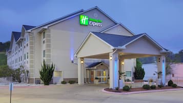 A Holiday Inn Express hotel with a covered entrance, multiple floors, and a landscaped front yard.