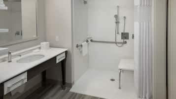 A modern bathroom with a shower, a sink, and a toilet.