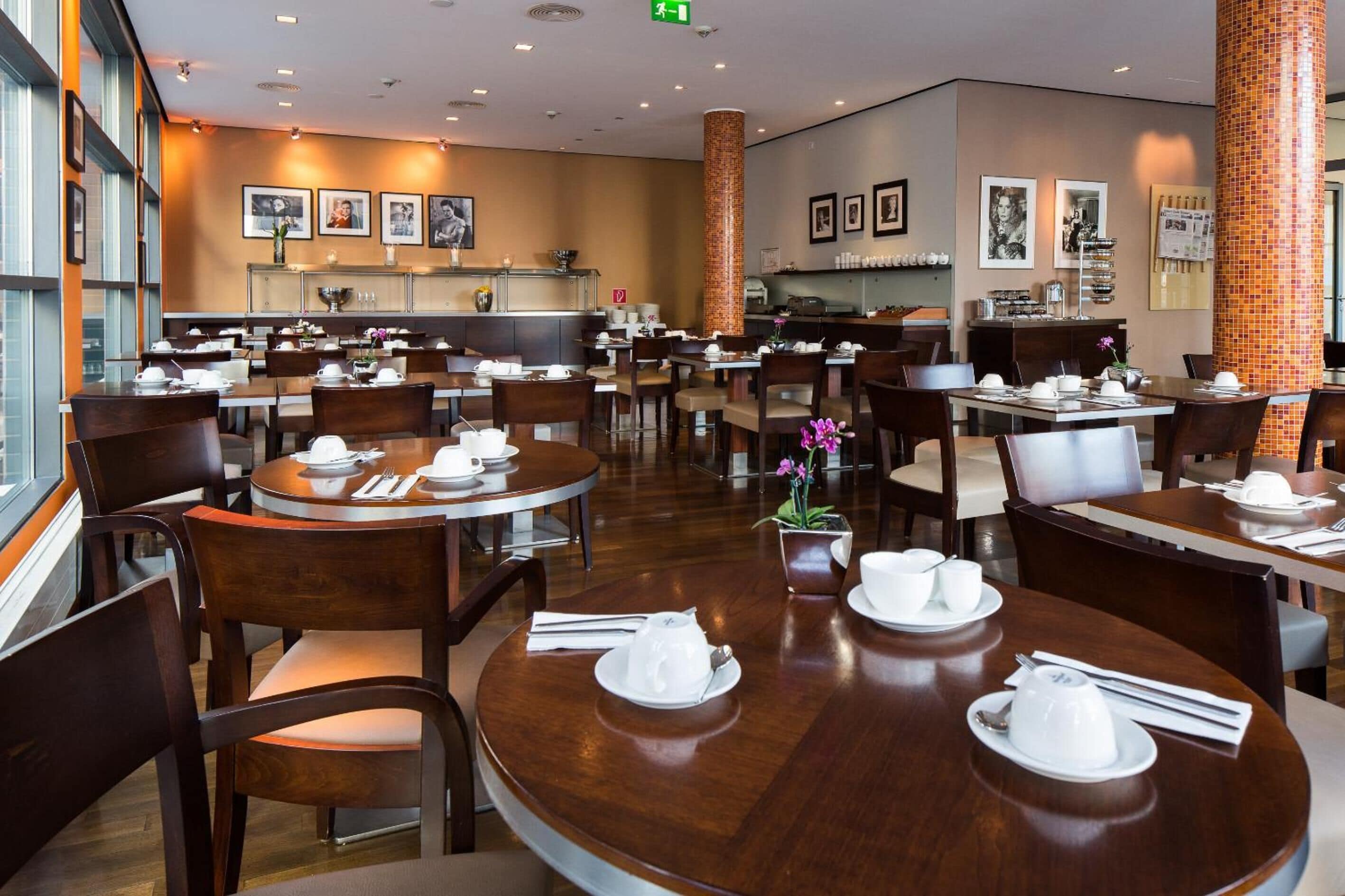A spacious restaurant with multiple round tables, each set with white dishes and napkins.