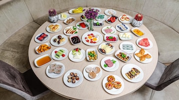Una mesa redonda con diferentes alimentos y un jarrón de flores.