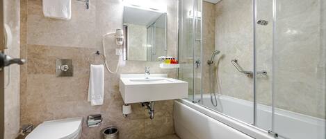 A modern bathroom with a toilet, sink, and shower.