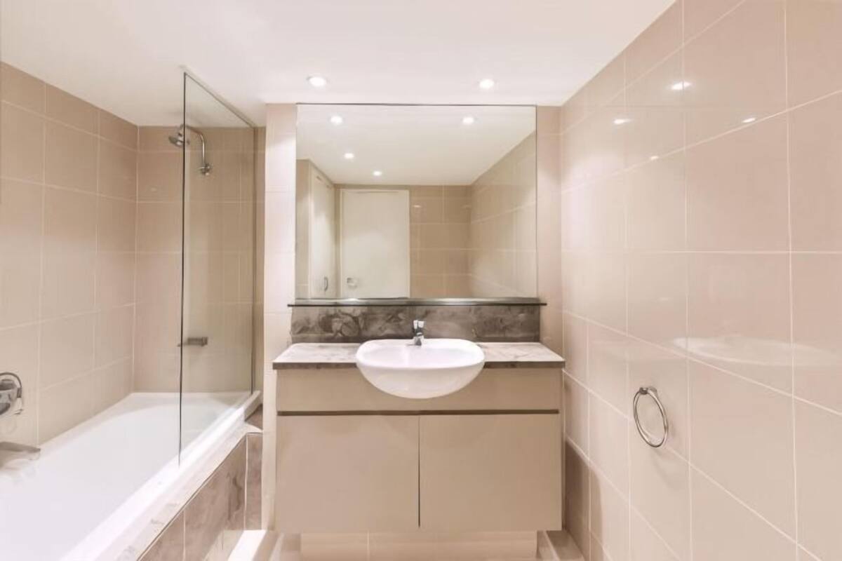 Un baño con una bañera, un lavamanos y un espejo.