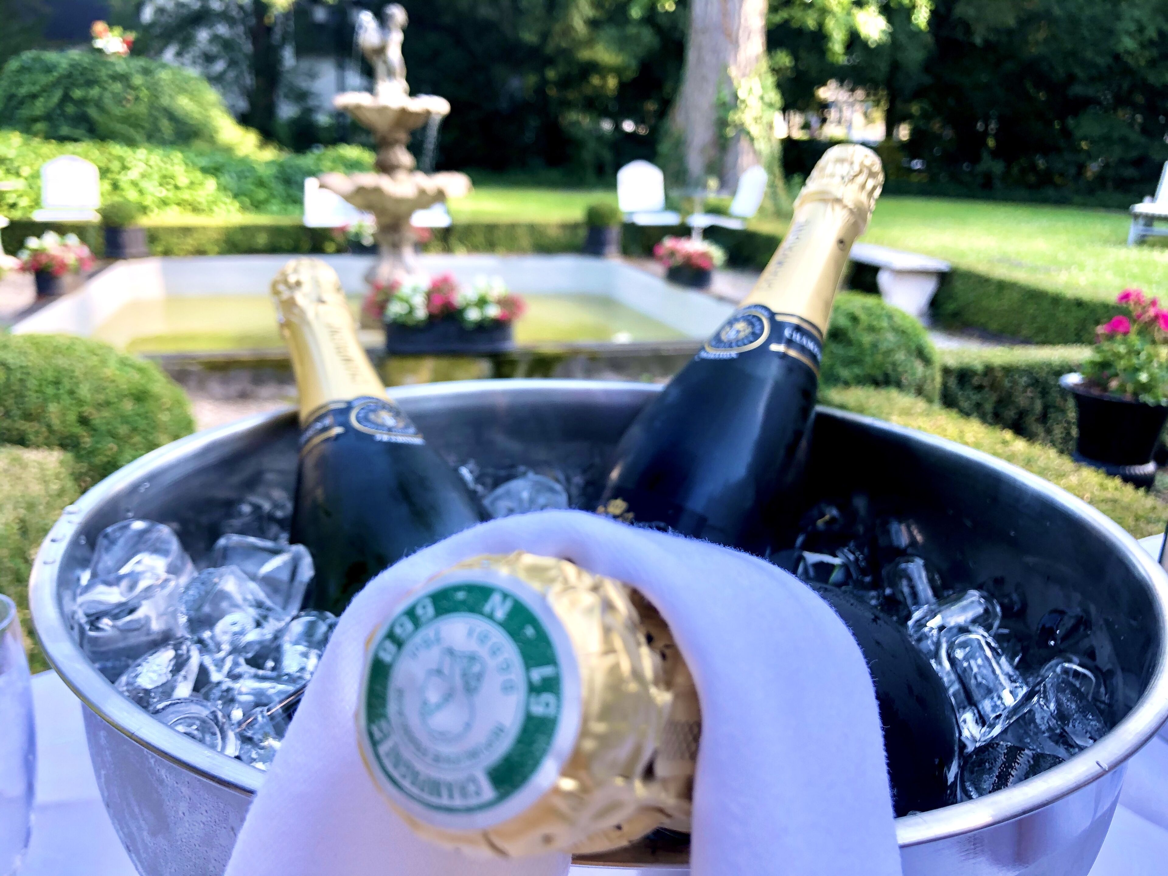 A bucket with two champagne bottles and ice cubes.