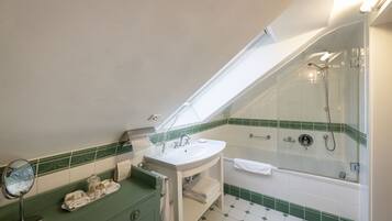 Un baño con tragaluz, lavamanos, espejo y ducha.