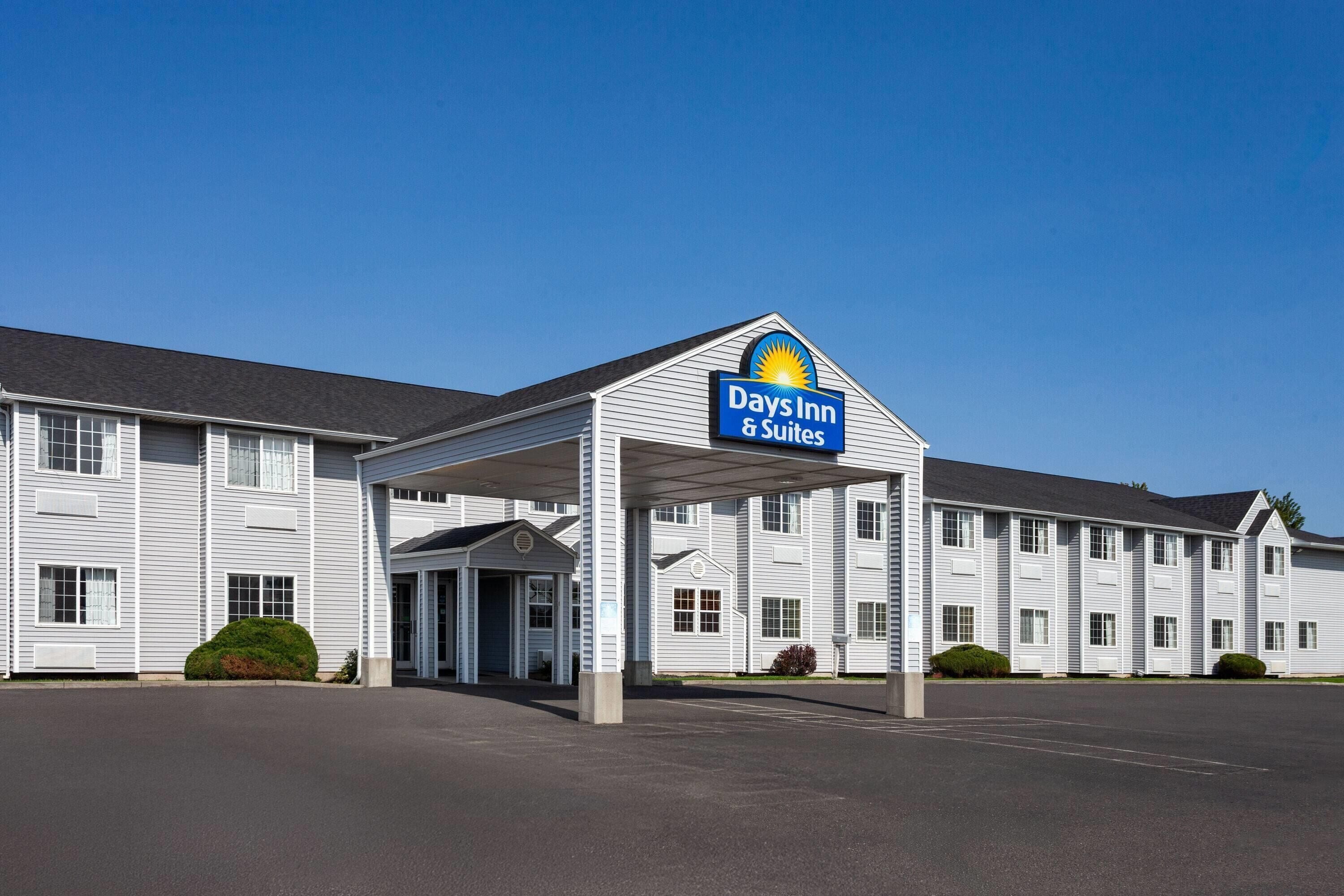 A Days Inn & Suites building with a covered entrance and a parking lot.