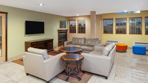 Ein Wohnzimmer mit einer Sofagarnitur, einem Couchtisch und einem an der Wand befestigten Flachbildfernseher.