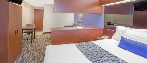 Een hotelkamer met een bed, een bureau, een stoel en een kledingkast.
