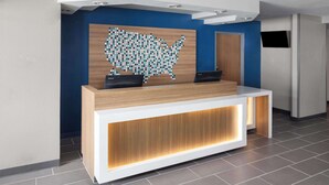 Un mostrador de recepción con detalles de madera y una pared azul de fondo.