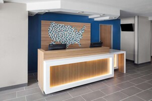 Un comptoir d’accueil avec un revêtement en bois et un mur bleu derrière.