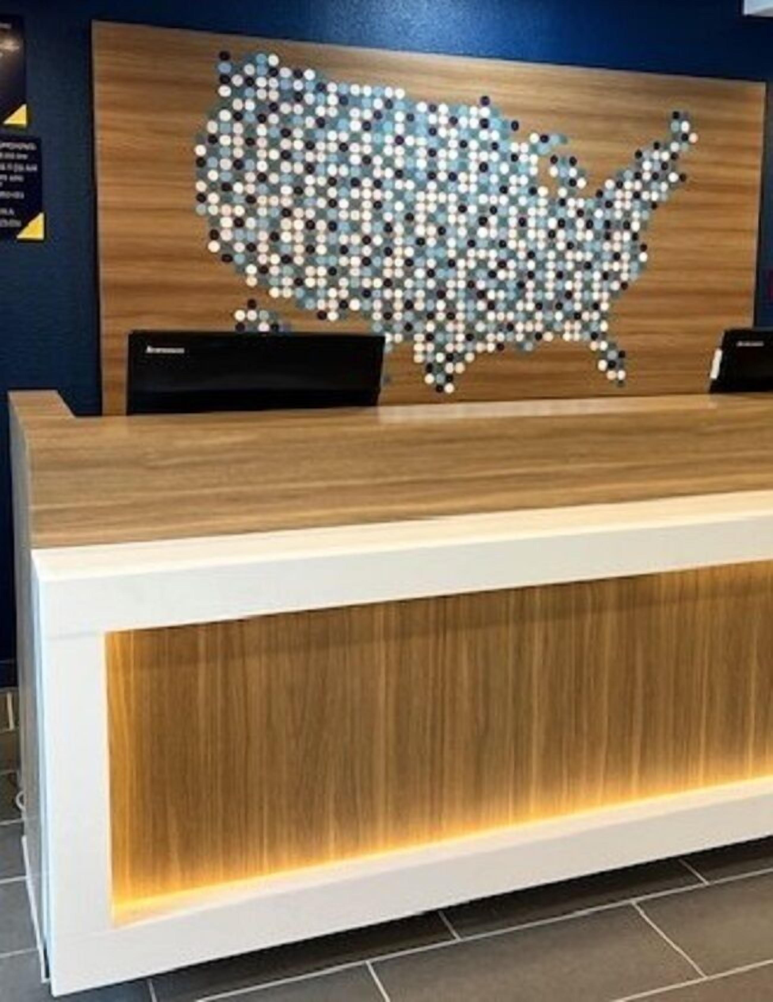 Un mostrador de recepción con detalles de madera y un panel frontal blanco.