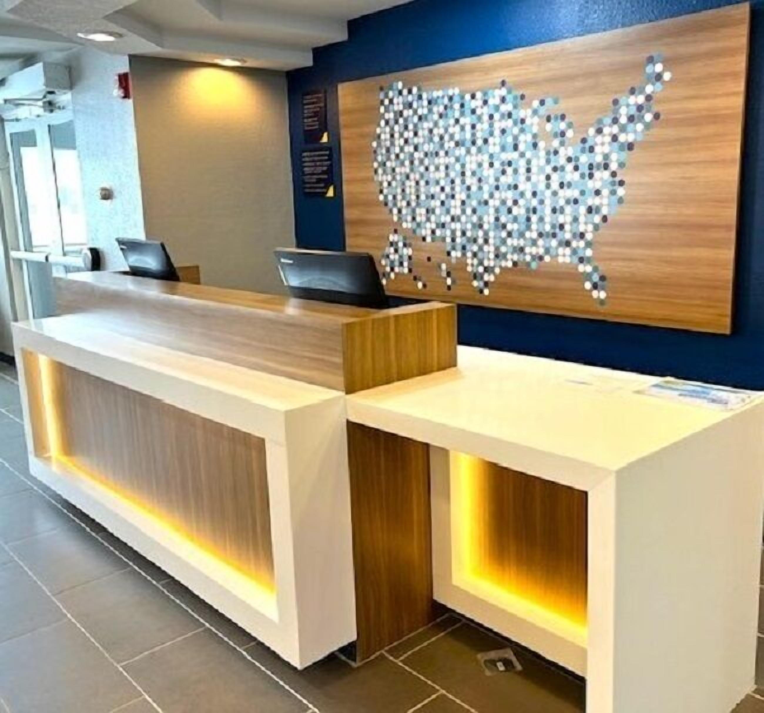 A reception desk with a wooden finish and integrated lighting.